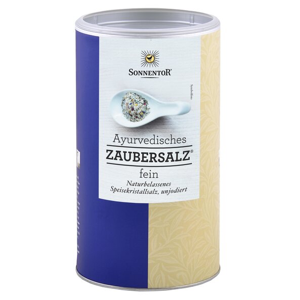 Ein Bild von einer großen Gastrodose Ayurvedisches Zaubersalz. Darauf zu sehen ist ein weißer Löffel mit vielen Gewürzen darauf.